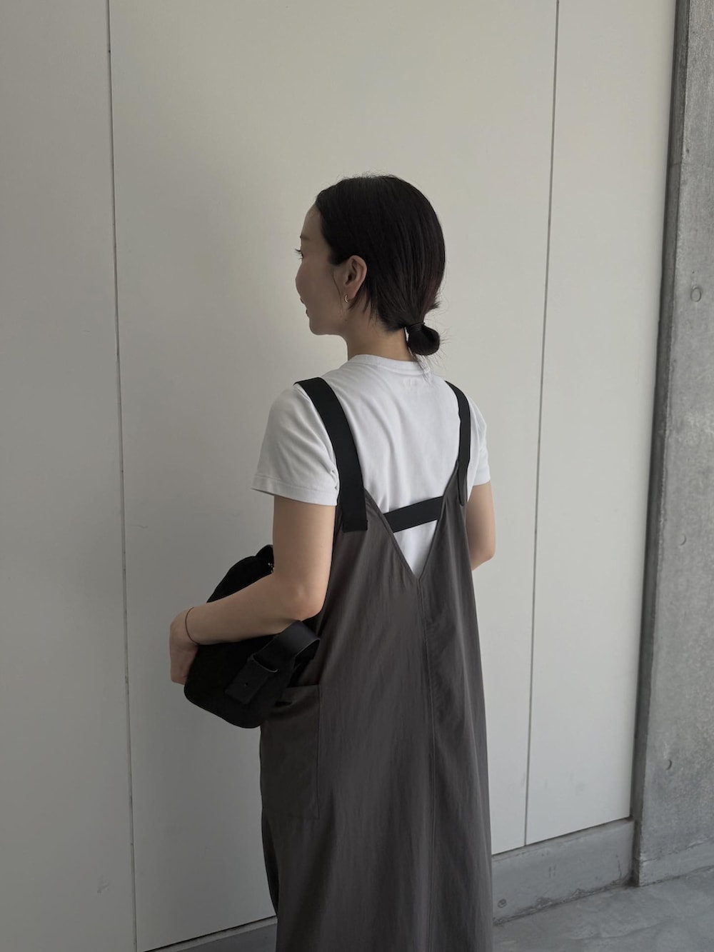 グレー系のジャンパースカート、ブラック系のハンドバッグを着用したレディースの夏コーディネートの3枚目の写真