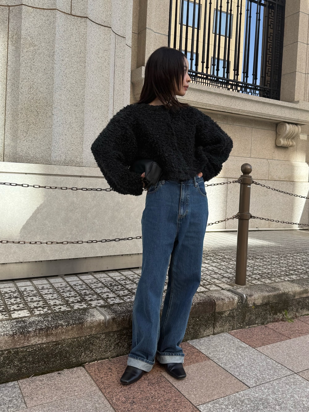 グレー系のカーディガン/ボレロ、ブルー系のデニムパンツ、ブラック系のスリッポンを着用したレディースの秋コーディネートの4枚目の写真