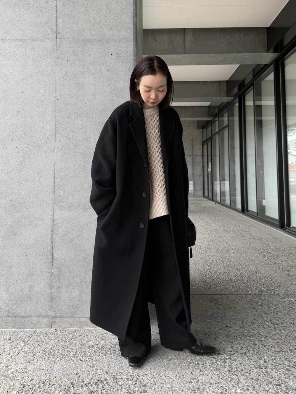 ホワイト系のニット/セーター、ブラック系のチェスターコート、ブラック系のその他パンツを着用したレディースの冬コーディネートの2枚目の写真