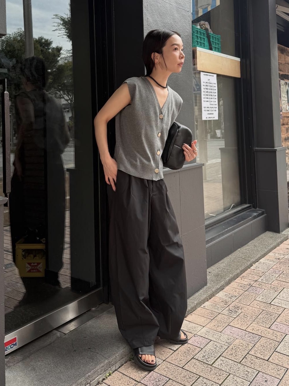 グレー系のベスト、ブラック系のその他パンツ、ブラック系のネックレスを着用したレディースの夏コーディネートの4枚目の写真