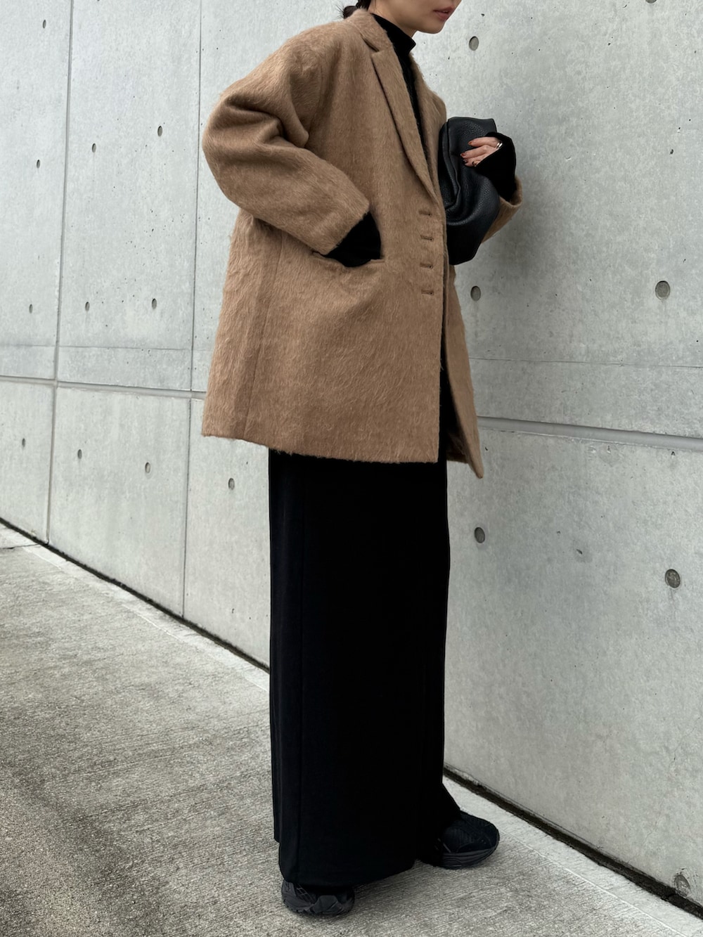 ブラウン系のテーラードジャケット、ブラック系のワンピース、ブラック系のスニーカーを着用したレディースの秋コーディネートの5枚目の写真