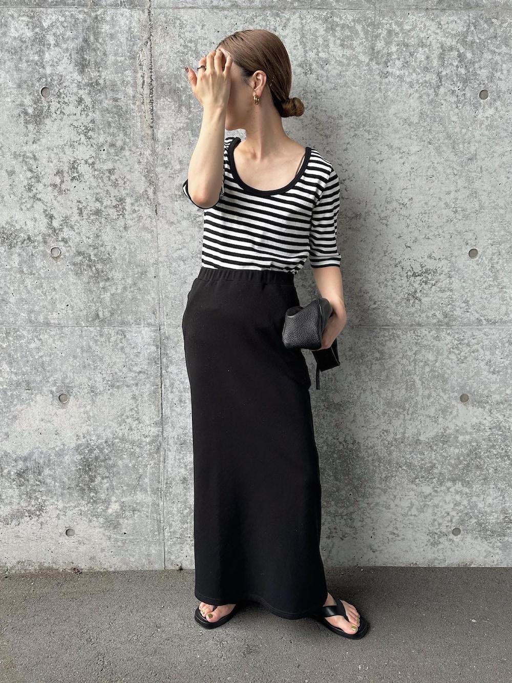 ブラック系のTシャツ/カットソー、ブラック系のスカート、ブラック系のサンダルを着用したレディースの夏コーディネートの3枚目の写真