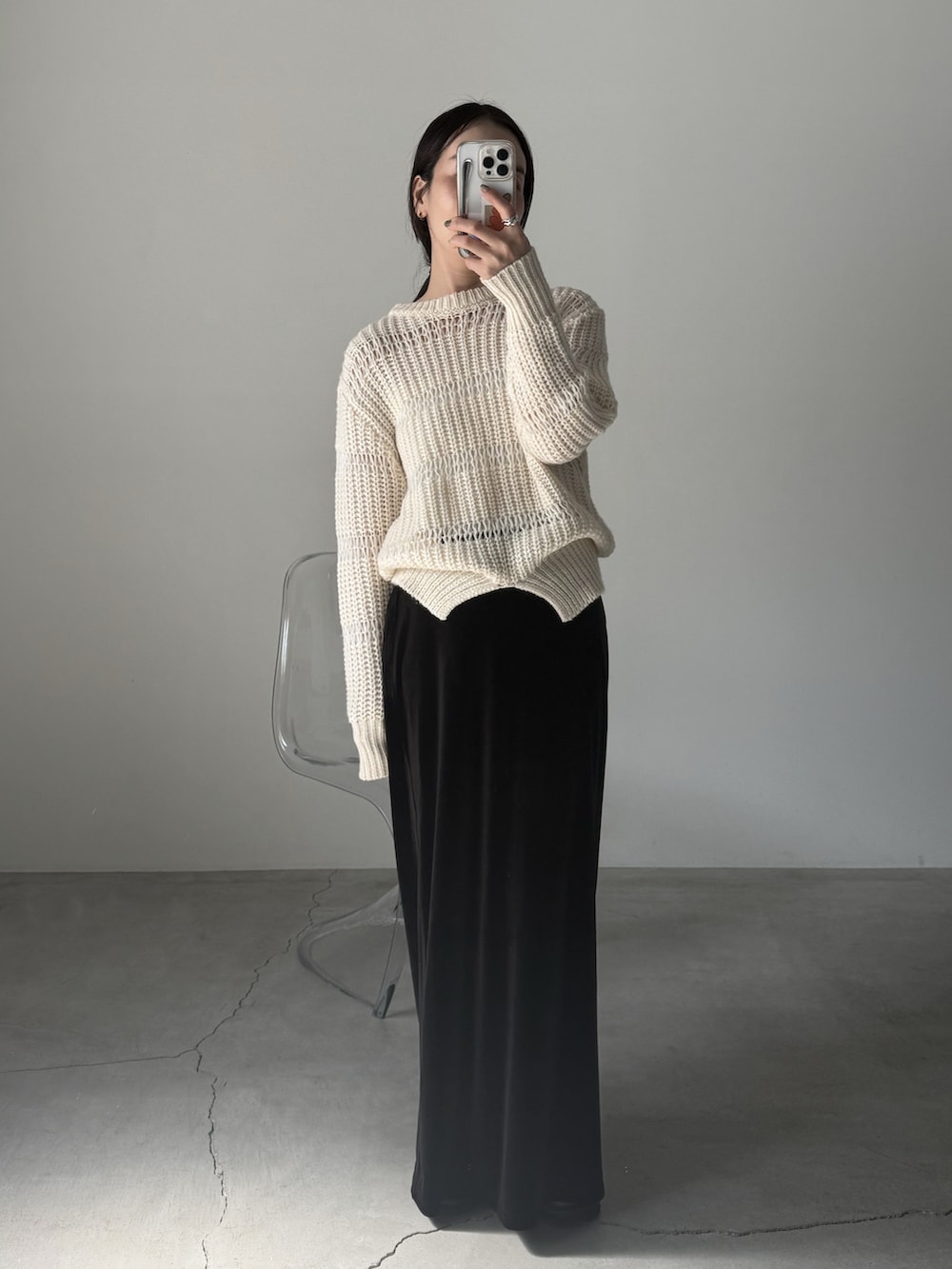 ホワイト系のニット/セーター、ブラック系のスカート、ブラック系のスニーカーを着用したレディースの秋コーディネートの5枚目の写真