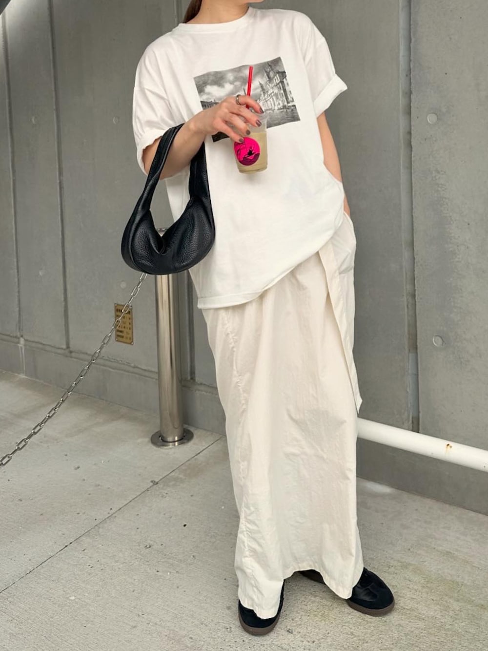 ホワイト系のTシャツ/カットソー、ホワイト系のスカート、ブラック系のスニーカーを着用したレディースの夏コーディネートの5枚目の写真