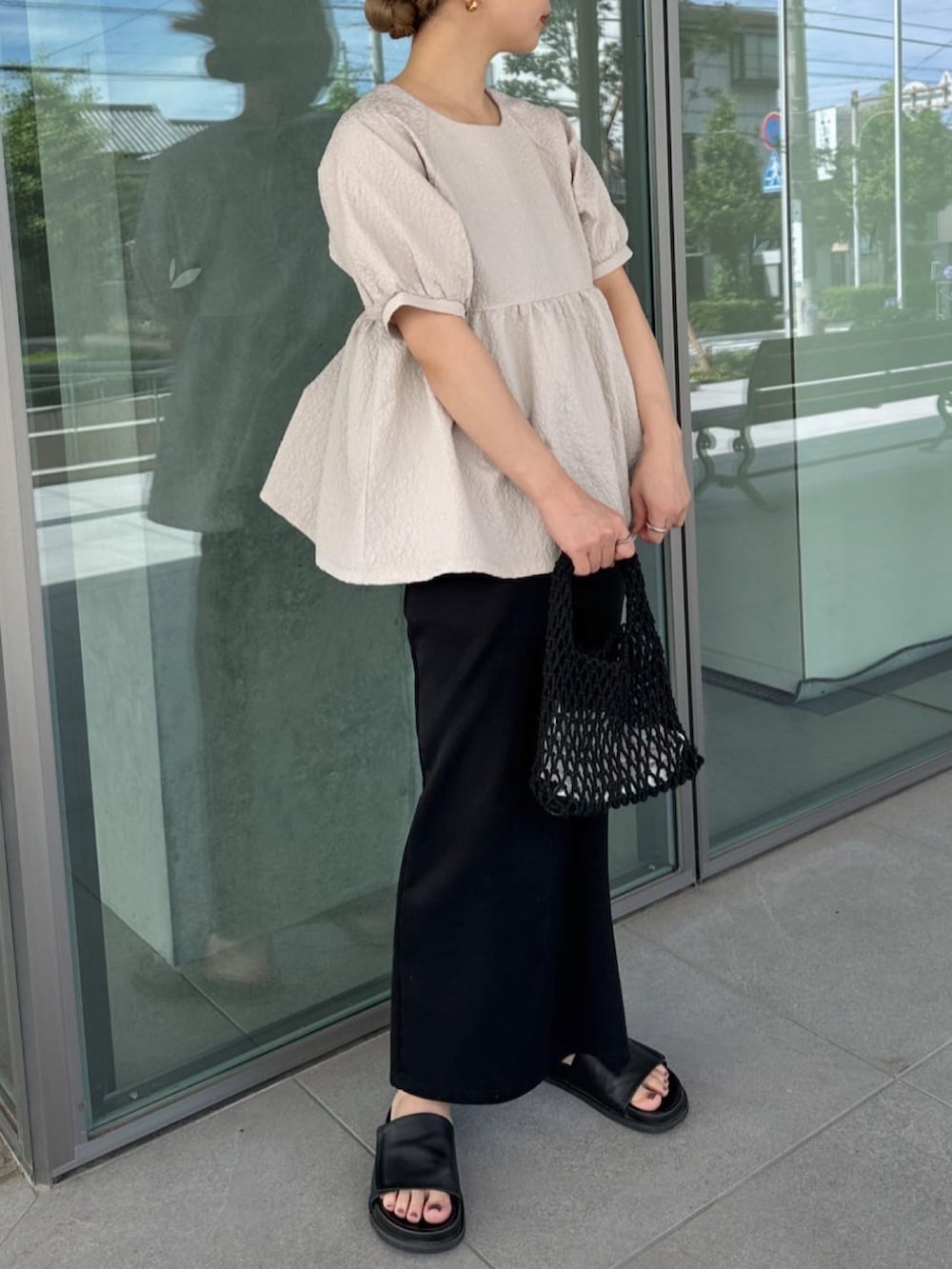 ベージュ系のシャツ/ブラウス、ブラック系のスカート、ブラック系のハンドバッグを着用したレディースの夏コーディネートの4枚目の写真