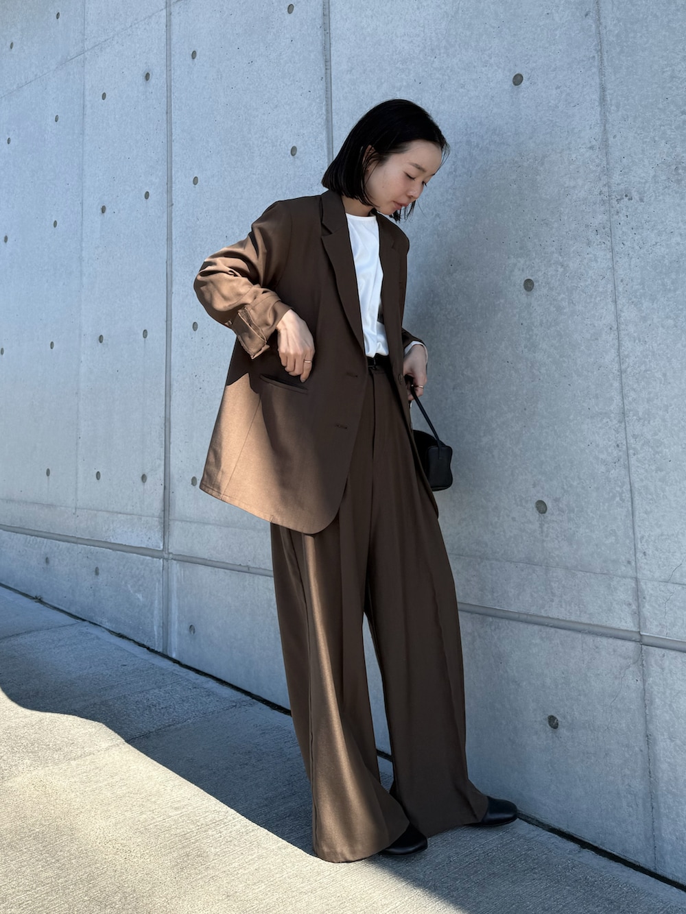 ブラウン系のテーラードジャケット、ホワイト系のシャツ/ブラウス、ブラウン系のスラックスを着用したレディースの冬コーディネートの4枚目の写真