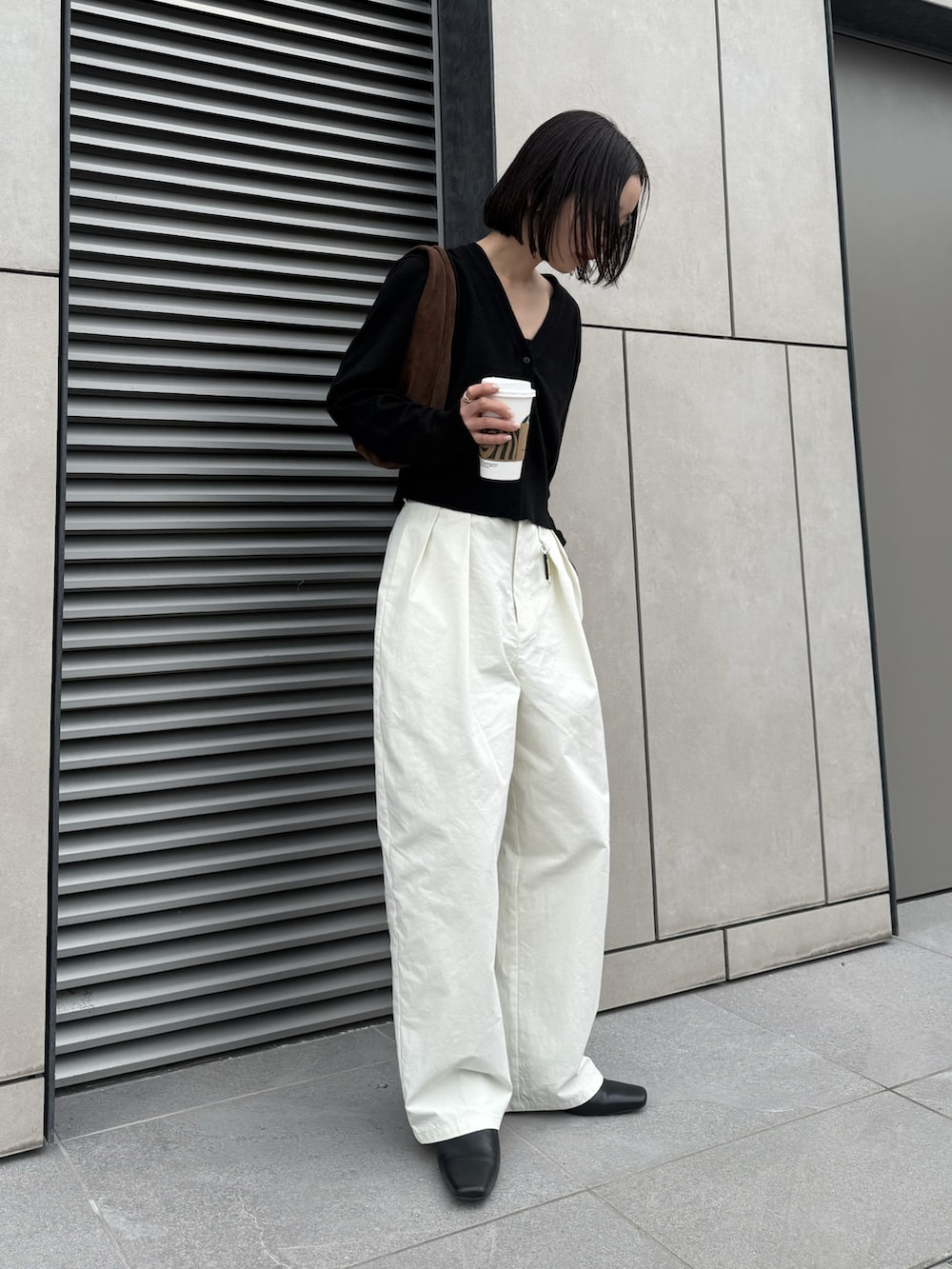 ブラック系のTシャツ/カットソー、ホワイト系のその他パンツ、ブラウン系のハンドバッグを着用したレディースの春コーディネートの4枚目の写真