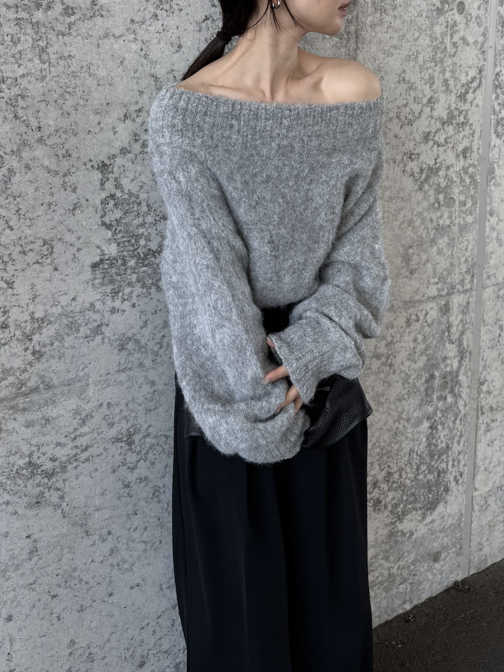 グレー系のニット/セーター、ブラック系のその他パンツ、ブラック系のスニーカーを着用したレディースの秋コーディネートの2枚目の写真