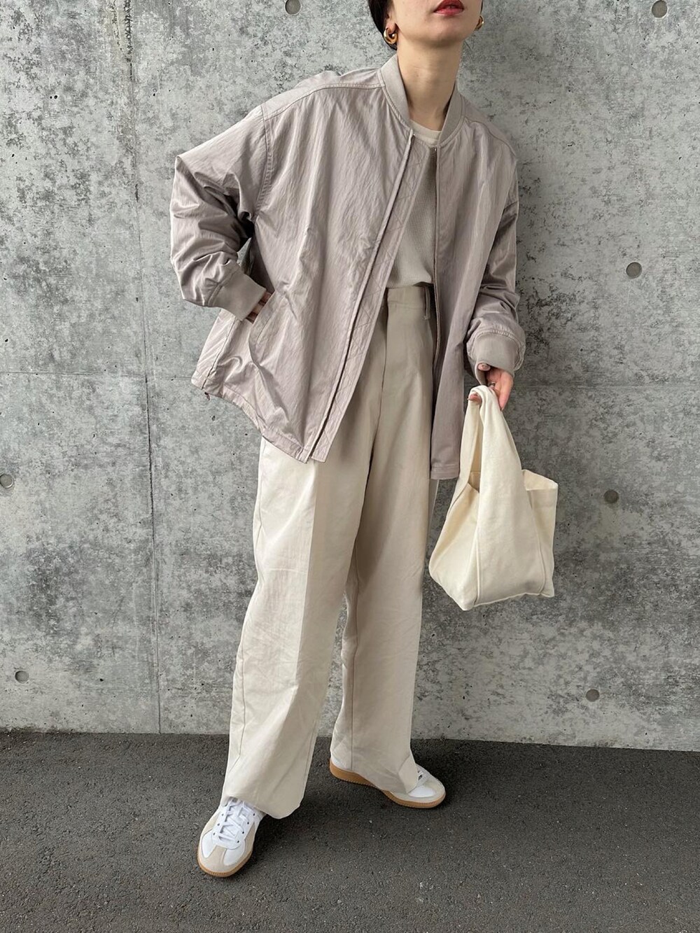 ベージュ系のブルゾン、ホワイト系のその他パンツ、ホワイト系のトートバッグを着用したレディースの冬コーディネートの2枚目の写真