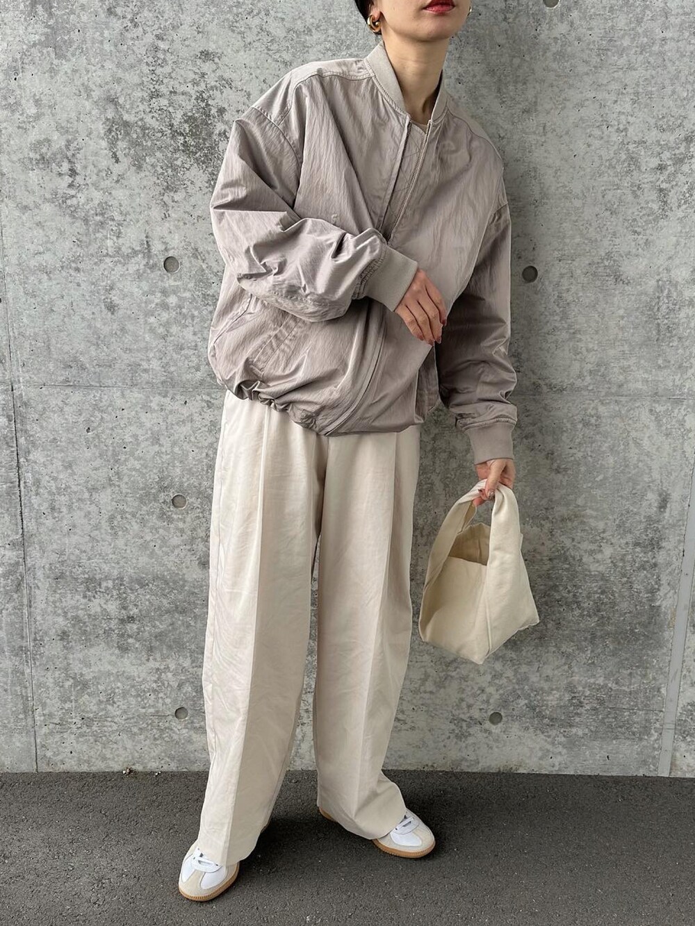 ベージュ系のブルゾン、ホワイト系のその他パンツ、ホワイト系のトートバッグを着用したレディースの冬コーディネートの3枚目の写真