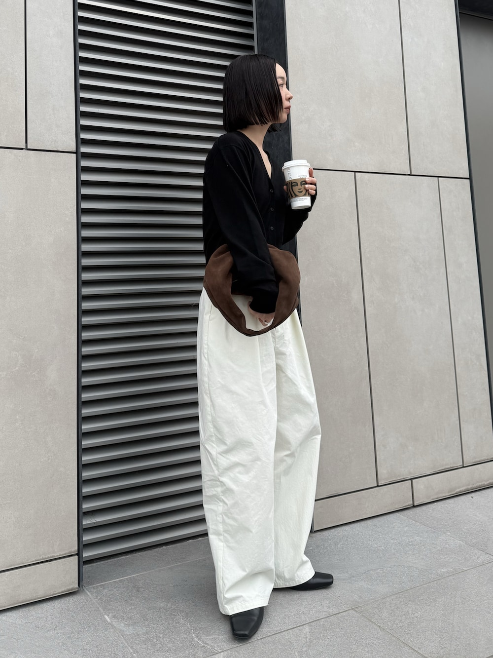 ブラック系のTシャツ/カットソー、ホワイト系のその他パンツ、ブラウン系のハンドバッグを着用したレディースの春コーディネートの2枚目の写真