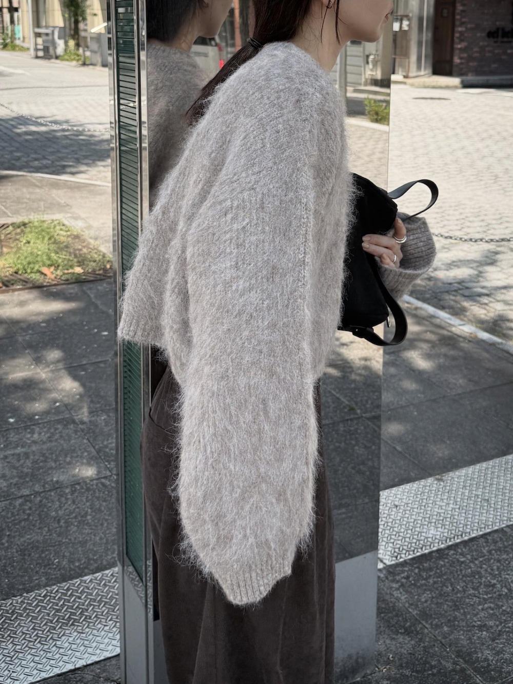 ブラウン系のニット/セーター、ブラウン系のスラックス、ブラウン系のスニーカーを着用したレディースの秋コーディネートの2枚目の写真