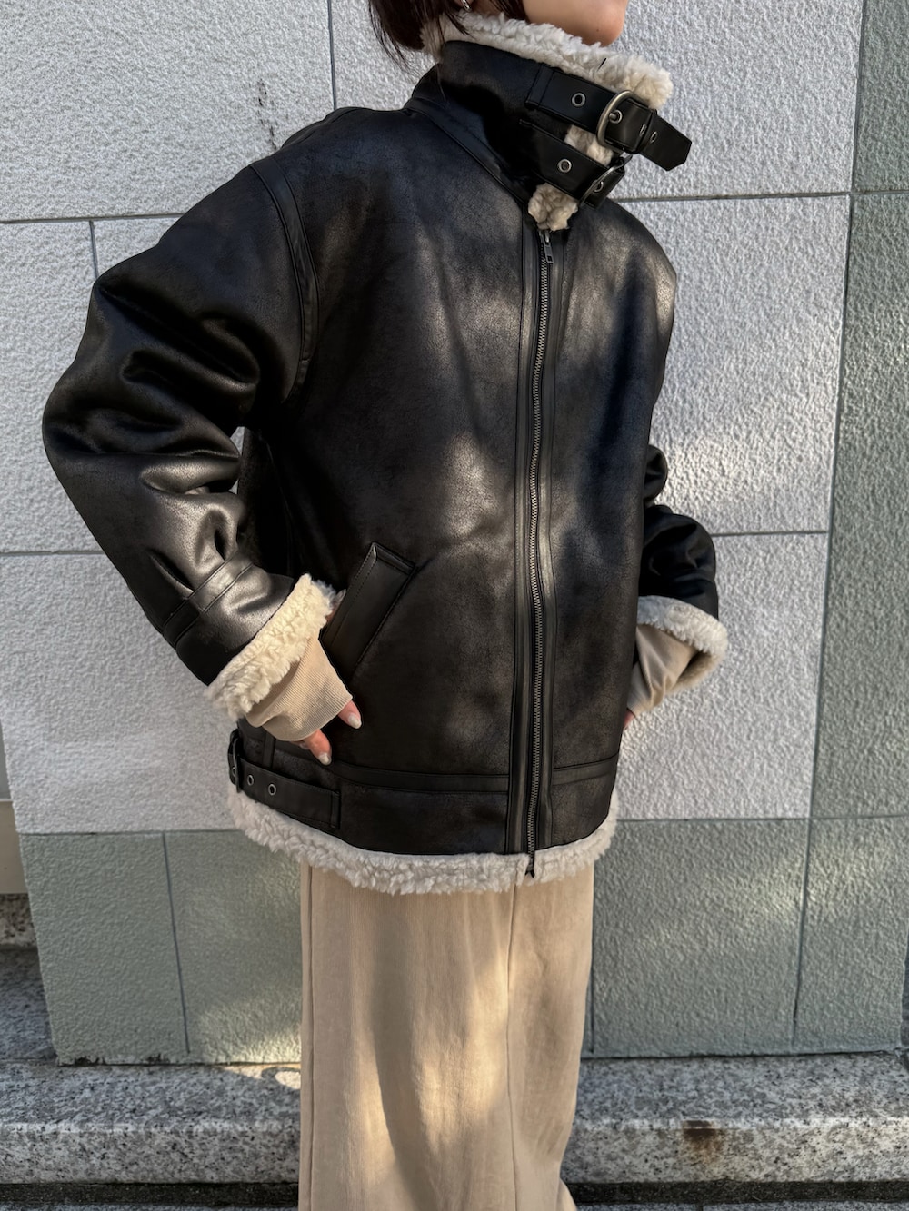 ベージュ系のワンピース、ブラック系のブルゾン、ブラック系のスニーカーを着用したレディースの秋コーディネートの4枚目の写真