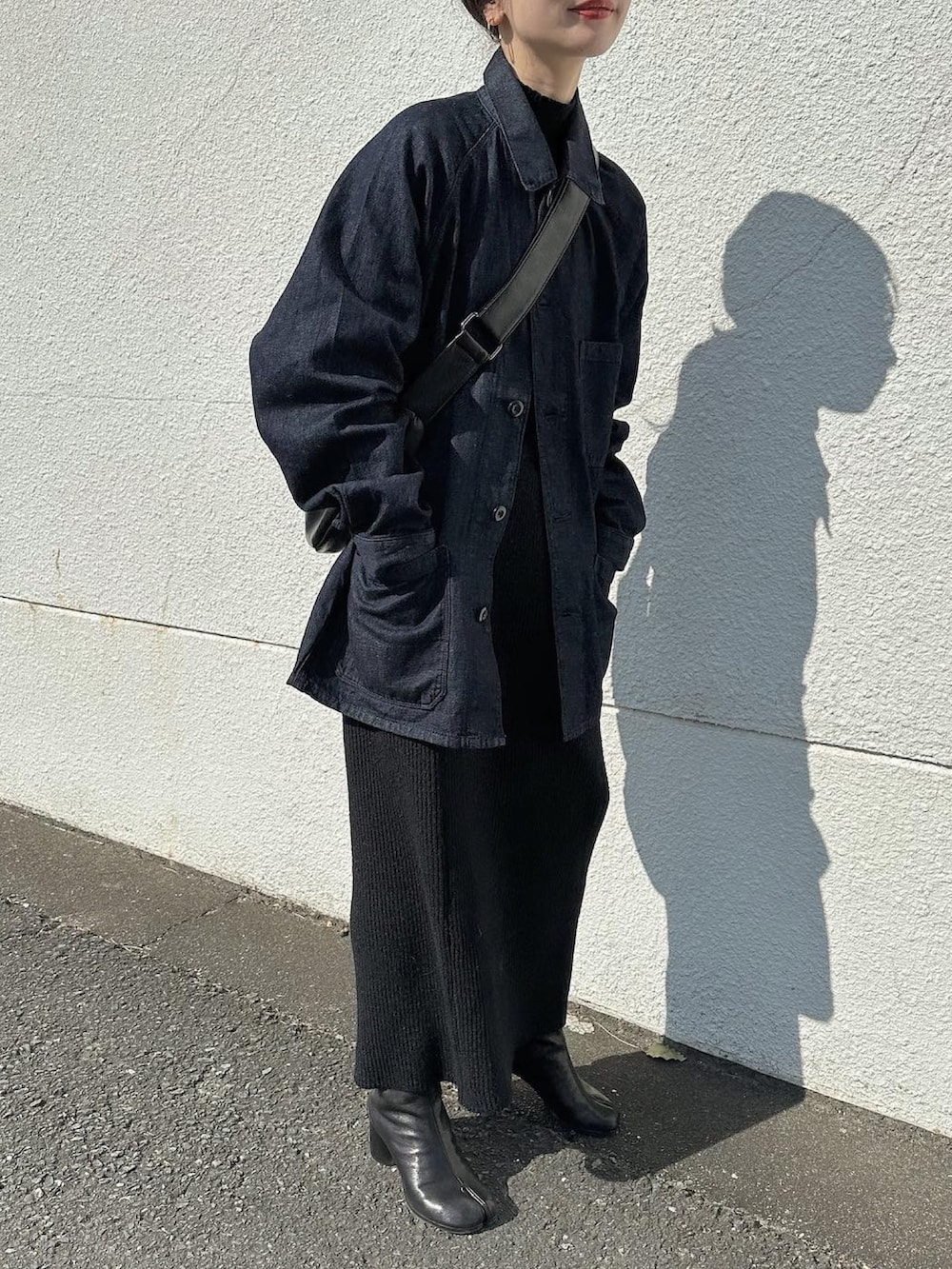 ブルー系のデニムジャケット、ブラック系のショルダーバッグ、ブラック系のニット/セーターを着用したレディースの冬コーディネートの4枚目の写真