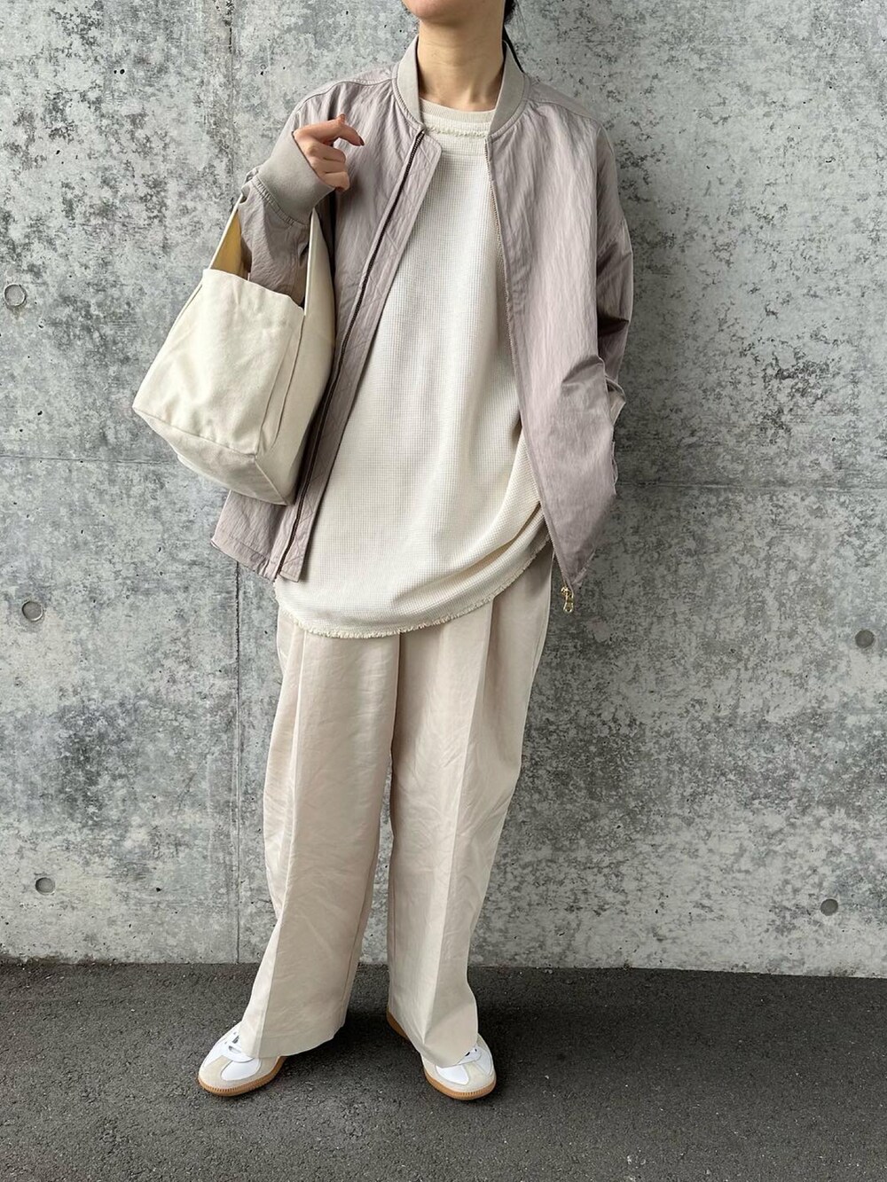 ベージュ系のブルゾン、ホワイト系のその他パンツ、ホワイト系のトートバッグを着用したレディースの冬コーディネートの4枚目の写真