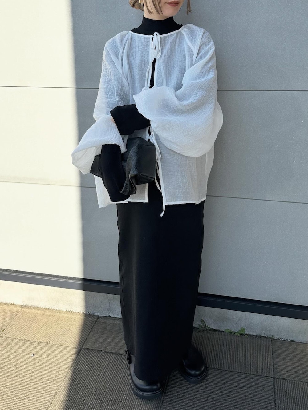 ホワイト系のシャツ/ブラウス、ブラック系のワンピース、ブラック系のスリッポンを着用したレディースの春コーディネートの2枚目の写真