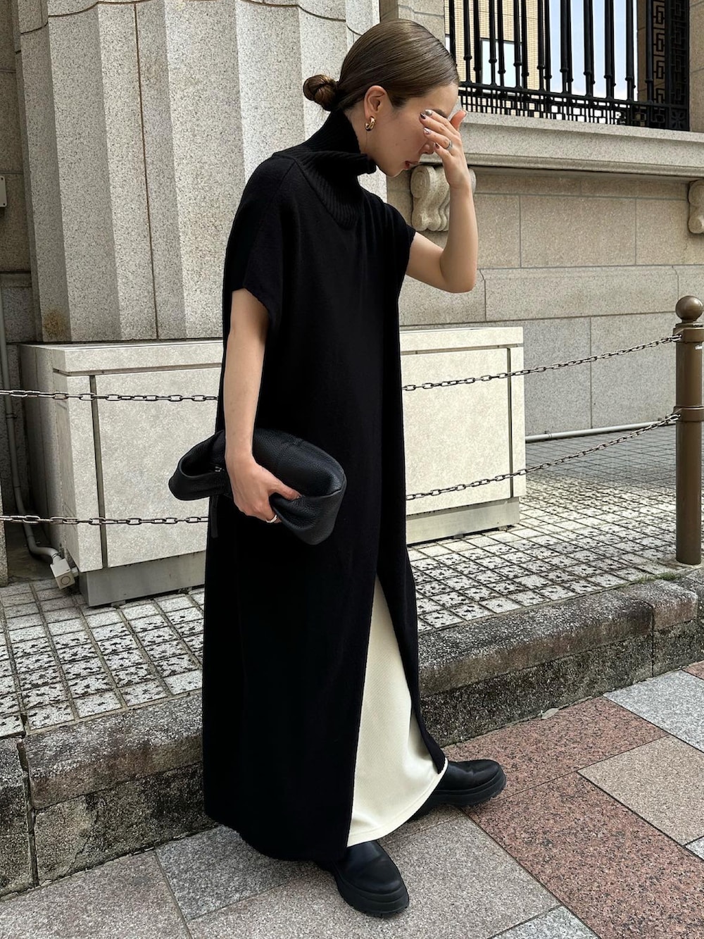 ブラック系のワンピース、ホワイト系のスカート、ブラック系のハンドバッグを着用したレディースの秋コーディネートの3枚目の写真