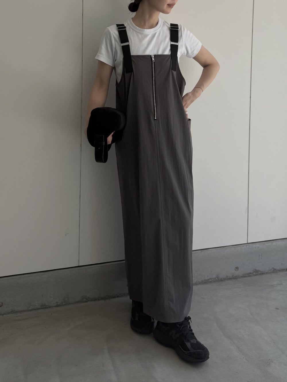 グレー系のジャンパースカート、ブラック系のハンドバッグを着用したレディースの夏コーディネートの4枚目の写真