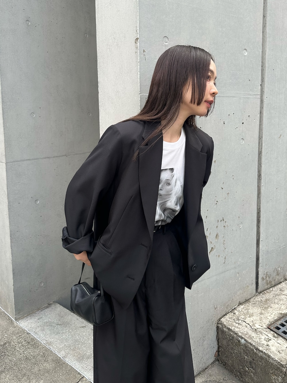 ブラック系のテーラードジャケット、ブラック系のスラックス、ホワイト系のTシャツ/カットソーを着用したレディースの春コーディネートの3枚目の写真