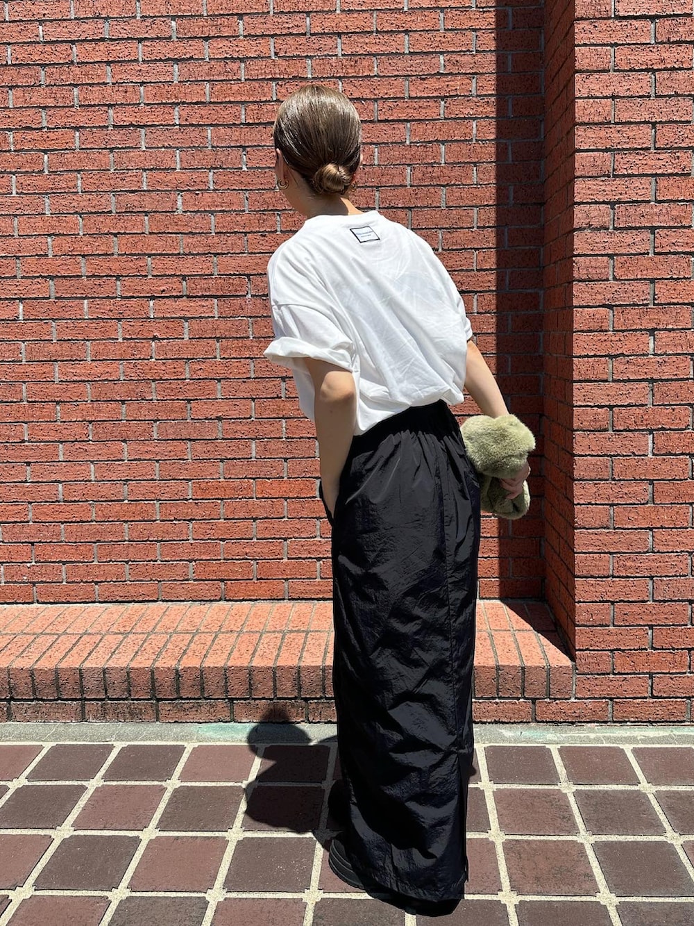 ホワイト系のTシャツ/カットソー、ブラック系のブーツ、グリーン系のハンドバッグを着用したレディースの夏コーディネートの4枚目の写真