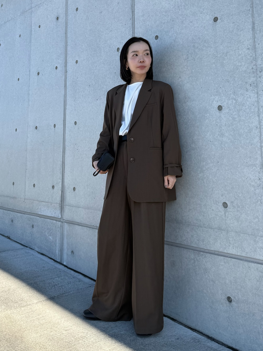 ブラウン系のテーラードジャケット、ホワイト系のシャツ/ブラウス、ブラウン系のスラックスを着用したレディースの冬コーディネートの5枚目の写真