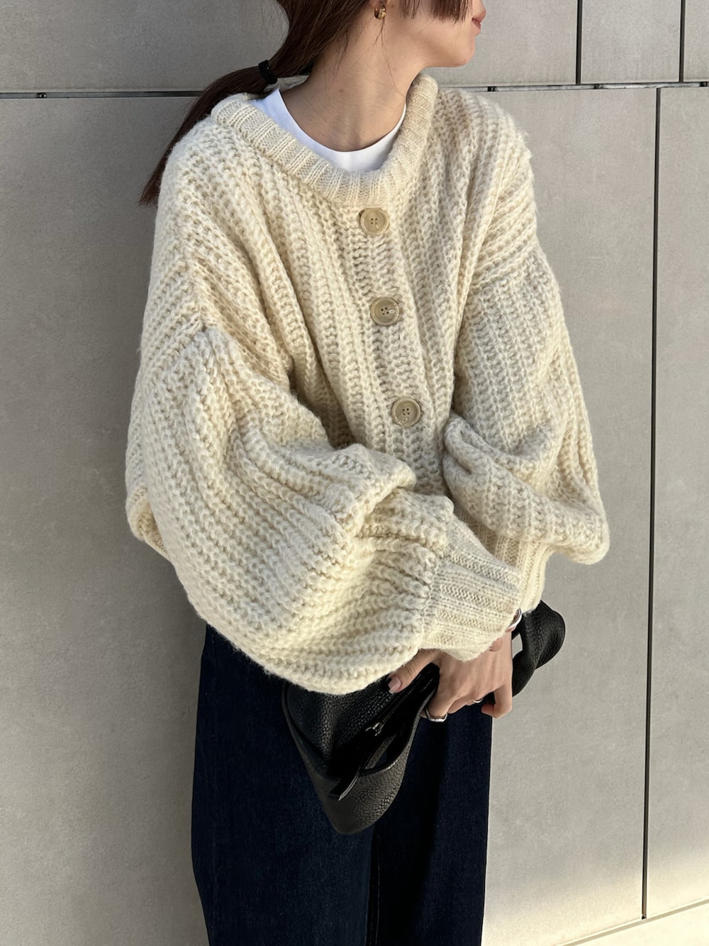 ホワイト系のカーディガン/ボレロ、ホワイト系のTシャツ/カットソー、ブルー系のデニムパンツを着用したレディースの冬コーディネートの3枚目の写真