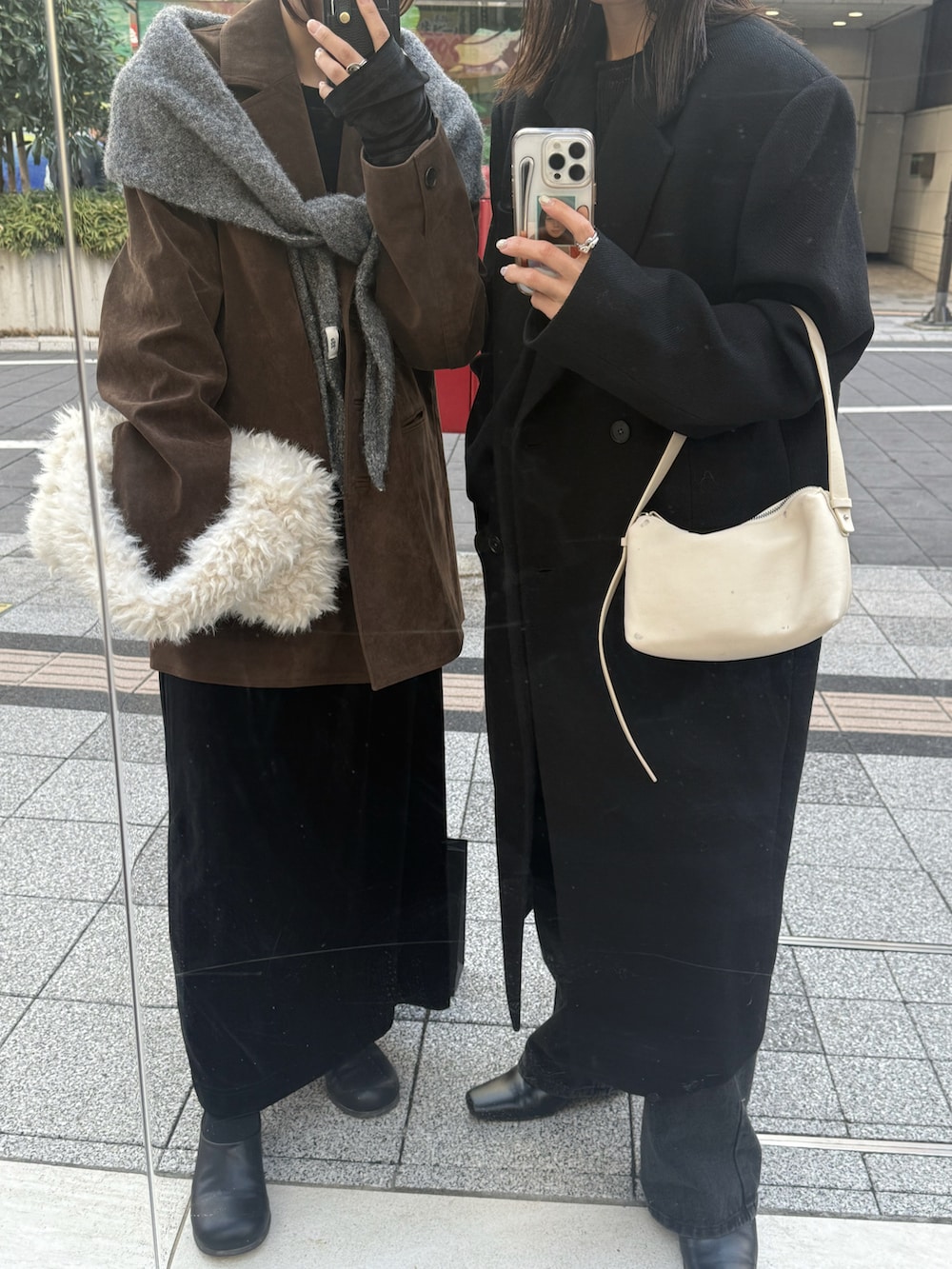 ブラック系のステンカラーコート、ブラック系のニット/セーター、ブラック系のデニムパンツを着用したレディースの秋コーディネートの4枚目の写真