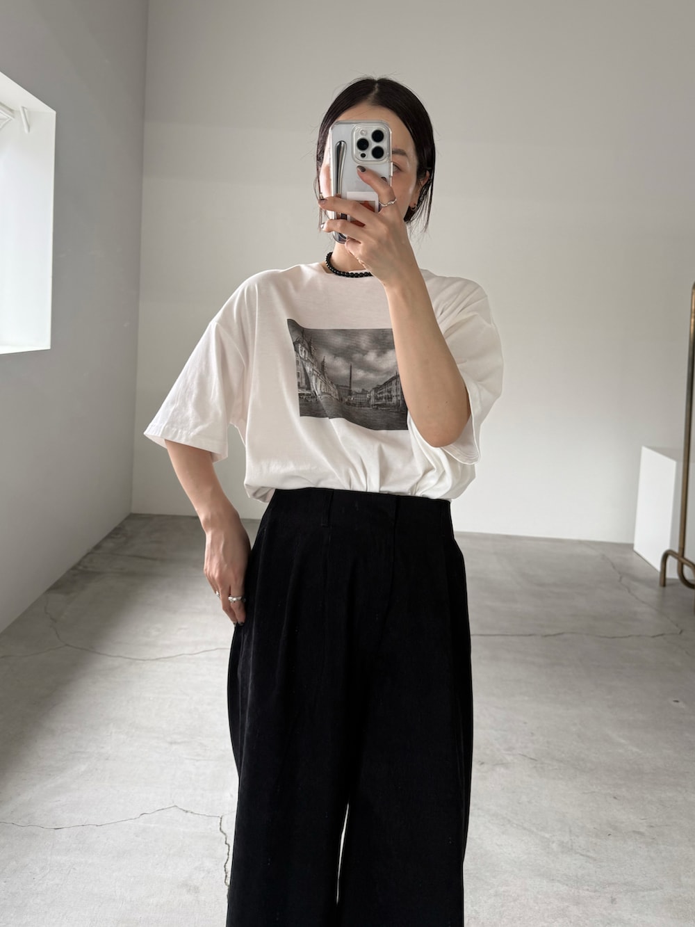 ホワイト系のTシャツ/カットソー、ブラック系のスラックス、ブラック系のネックレスを着用したレディースの夏コーディネートの4枚目の写真