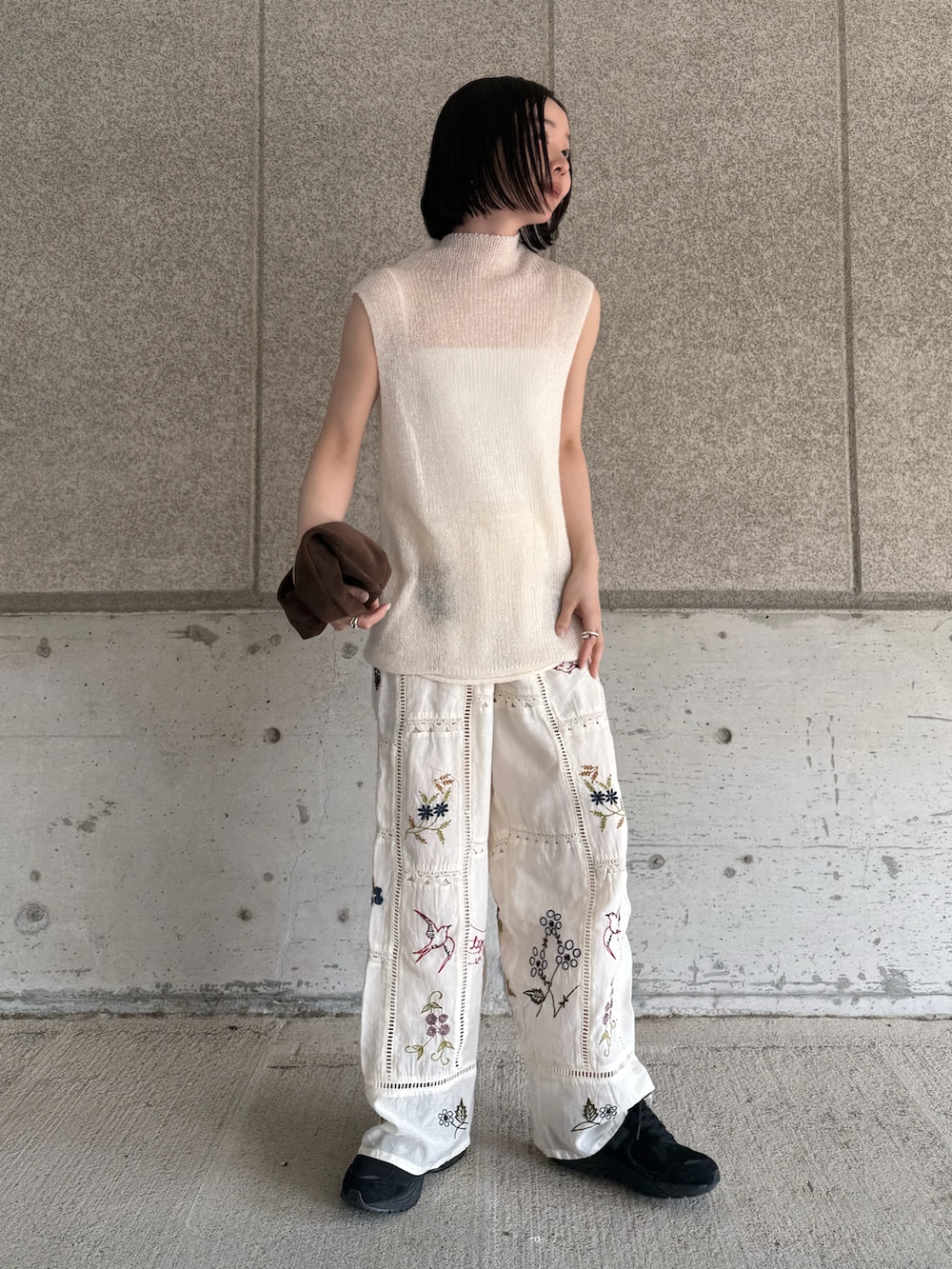 ホワイト系のニット/セーター、ホワイト系のその他パンツ、ブラウン系のハンドバッグを着用したレディースの春コーディネートの4枚目の写真