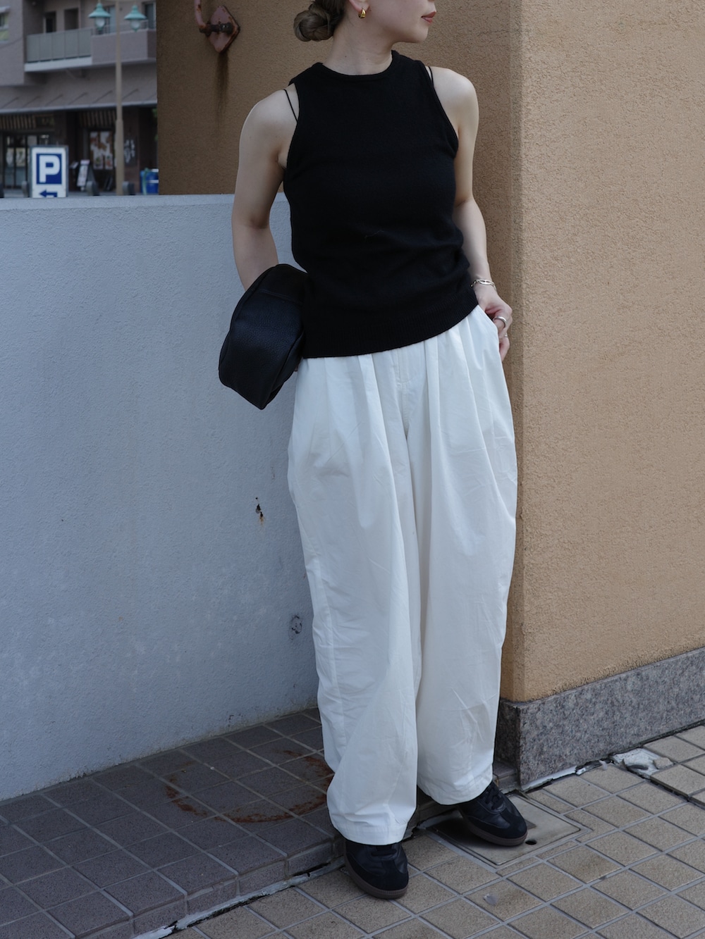 ブラック系のニット/セーター、ブラック系のキャミソール、ホワイト系のその他パンツを着用したレディースの夏コーディネートの3枚目の写真