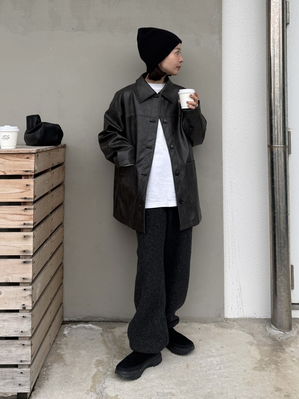 ブラック系のステンカラーコート、グレー系のデニムパンツ、ブラック系のその他シューズを着用したレディースの冬コーディネートの3枚目の写真