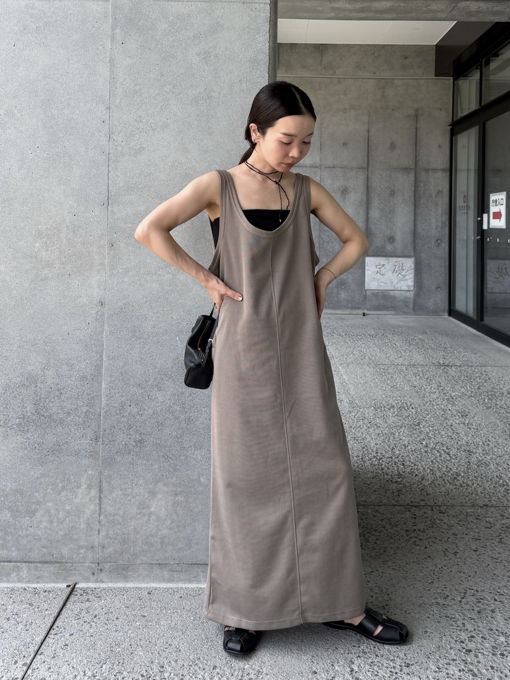 ベージュ系のワンピース、ブラック系のネックレスを着用したレディースの夏コーディネートの4枚目の写真