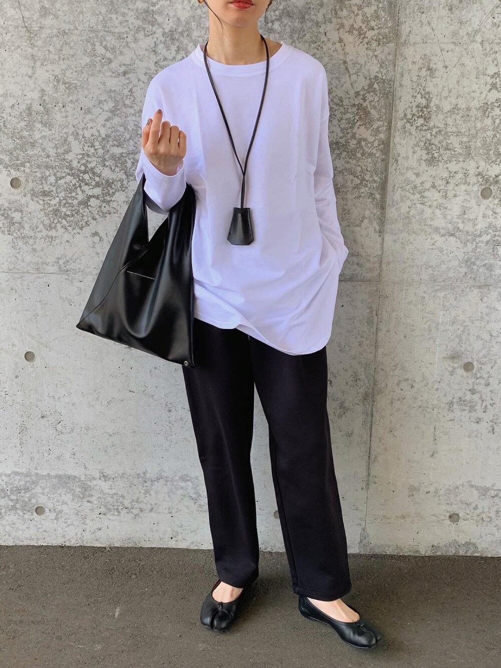 ホワイト系のTシャツ/カットソー、ホワイト系のパンツ、ブラック系のハンドバッグを着用したレディースの秋コーディネートの2枚目の写真