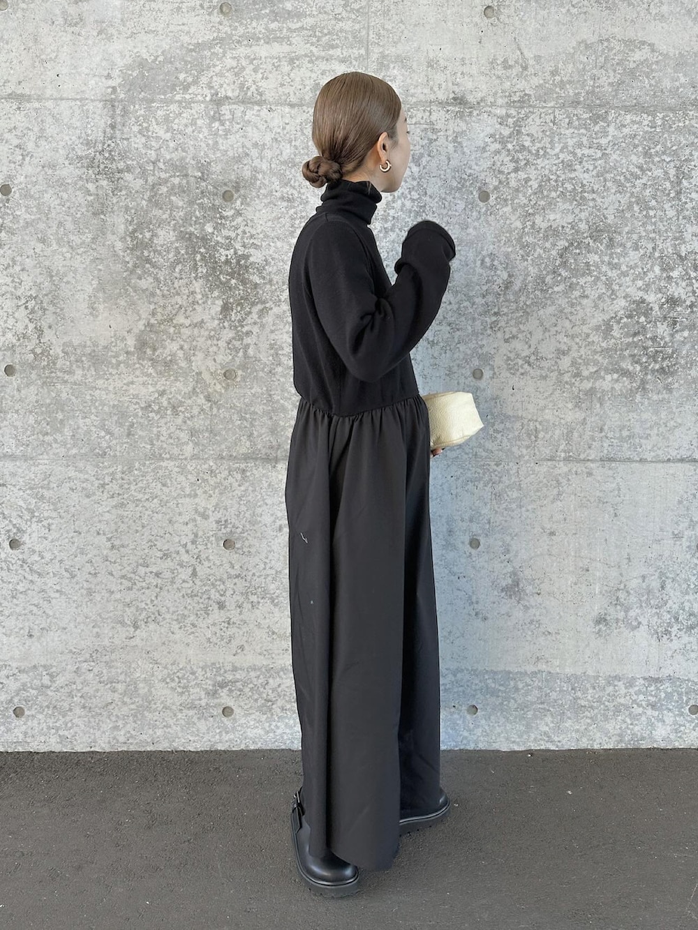 ブラック系のワンピース、ベージュ系のハンドバッグ、ブラック系のスリッポンを着用したレディースの冬コーディネートの5枚目の写真