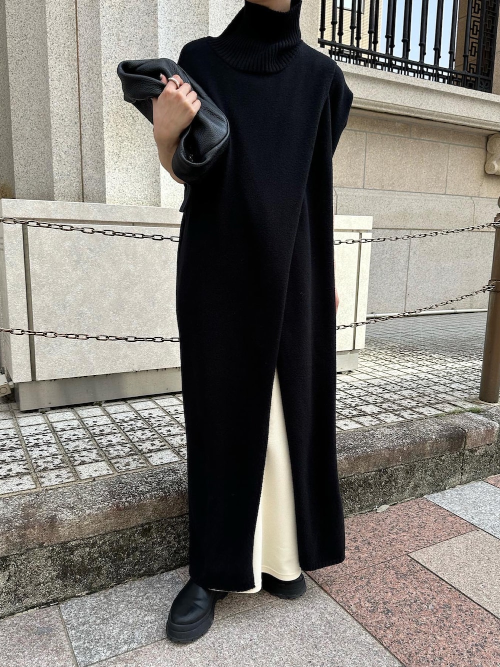 ブラック系のワンピース、ホワイト系のスカート、ブラック系のハンドバッグを着用したレディースの秋コーディネートの4枚目の写真