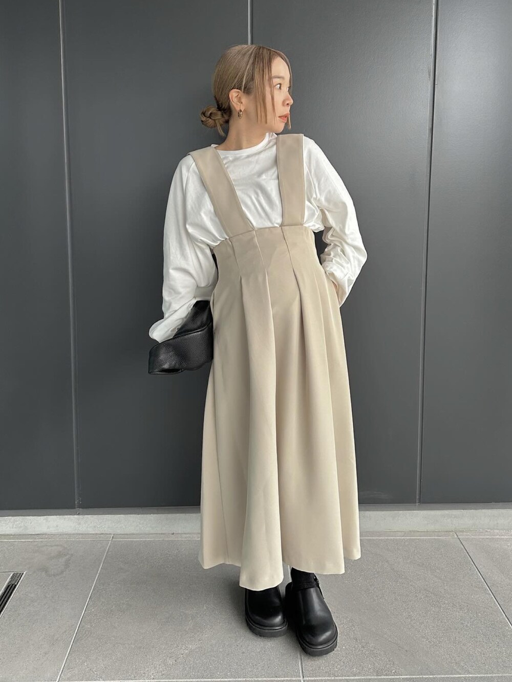 ベージュ系のスカート、ホワイト系のTシャツ/カットソー、ブラック系のスリッポンを着用したレディースの冬コーディネートの5枚目の写真