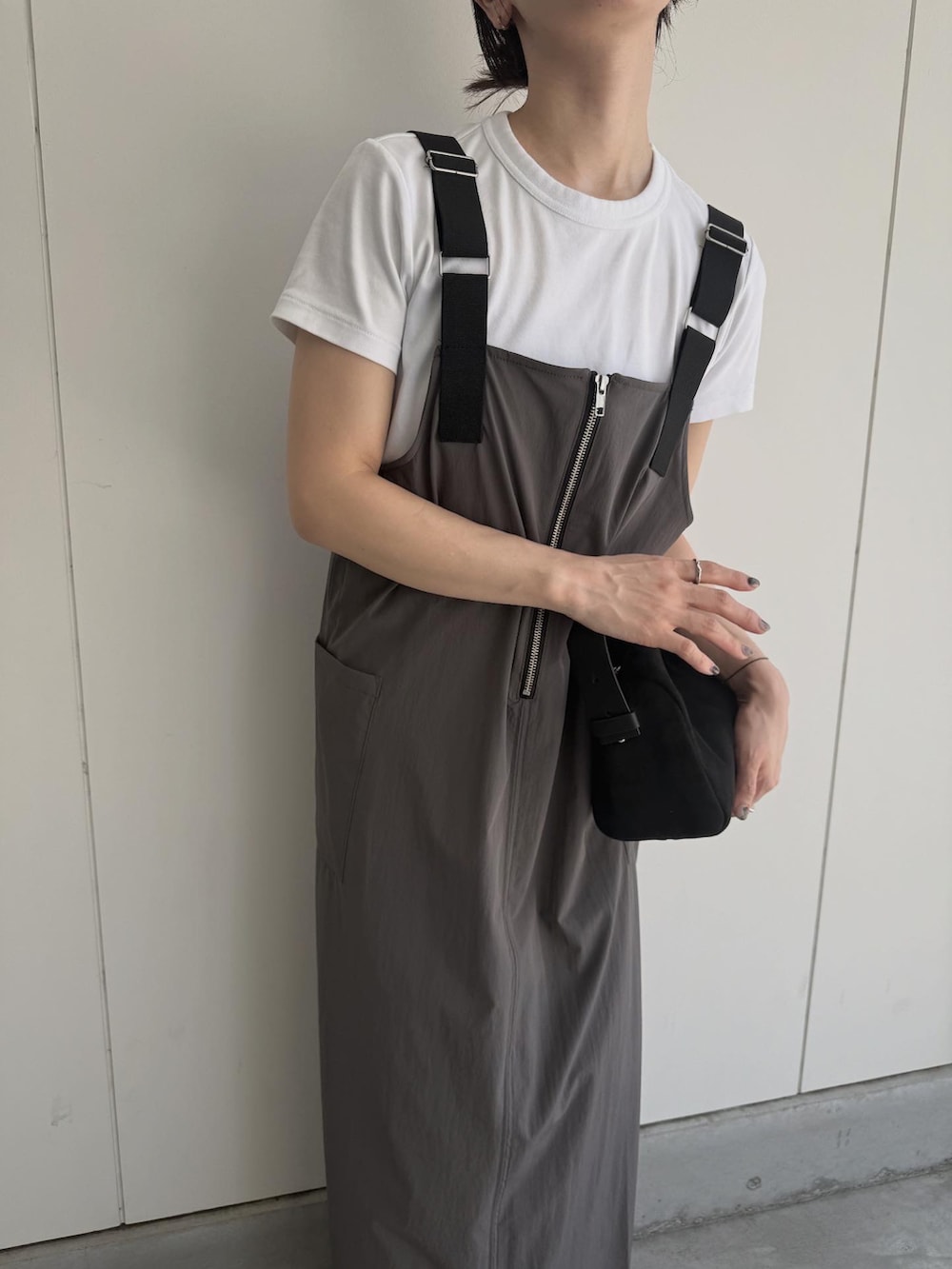 グレー系のジャンパースカート、ブラック系のハンドバッグを着用したレディースの夏コーディネートの5枚目の写真