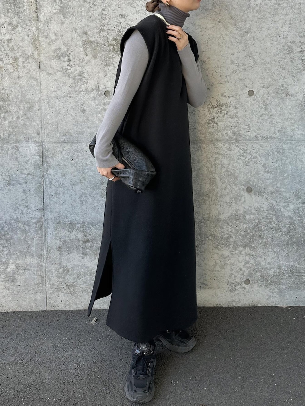 グレー系のニット/セーター、ブラック系のワンピース、ブラック系のスニーカーを着用したレディースの冬コーディネートの2枚目の写真