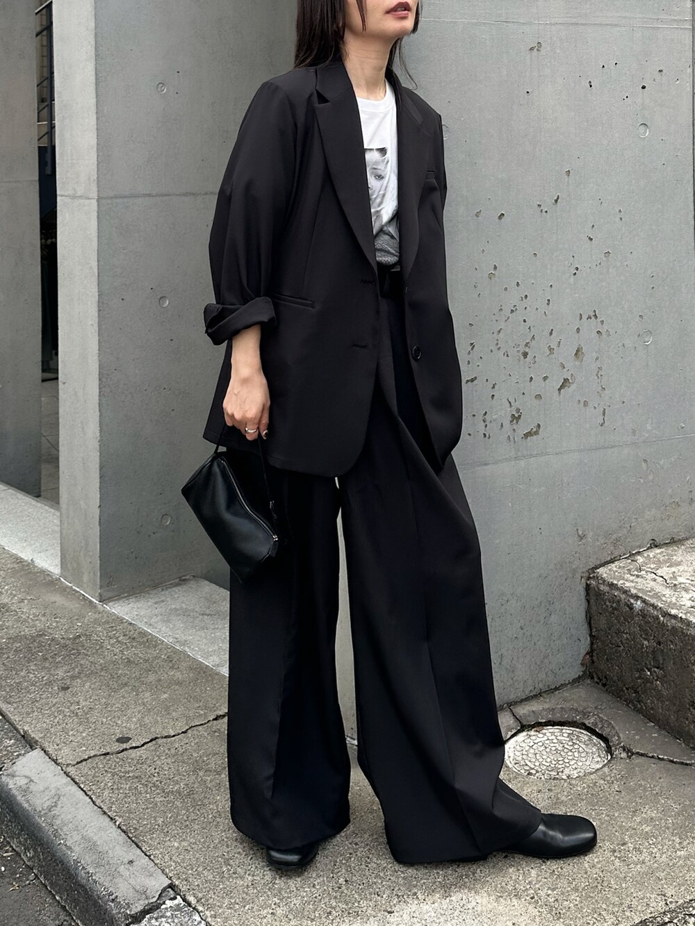 ブラック系のテーラードジャケット、ブラック系のスラックス、ホワイト系のTシャツ/カットソーを着用したレディースの春コーディネートの2枚目の写真