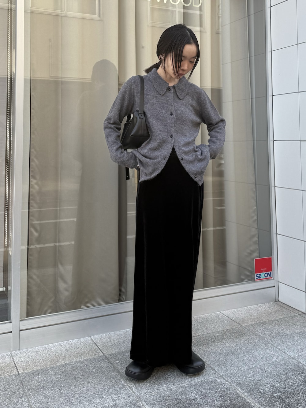 ブラック系のスカート、ブラック系のローファーを着用したレディースの冬コーディネートの5枚目の写真