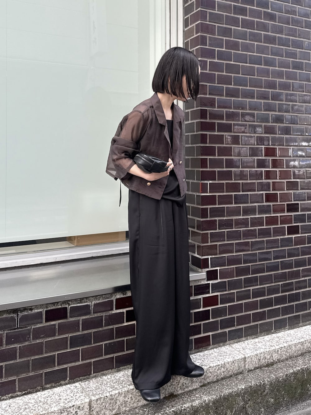 ブラウン系のテーラードジャケット、ブラック系のキャミソール、ブラック系のその他パンツを着用したレディースの春コーディネートの2枚目の写真
