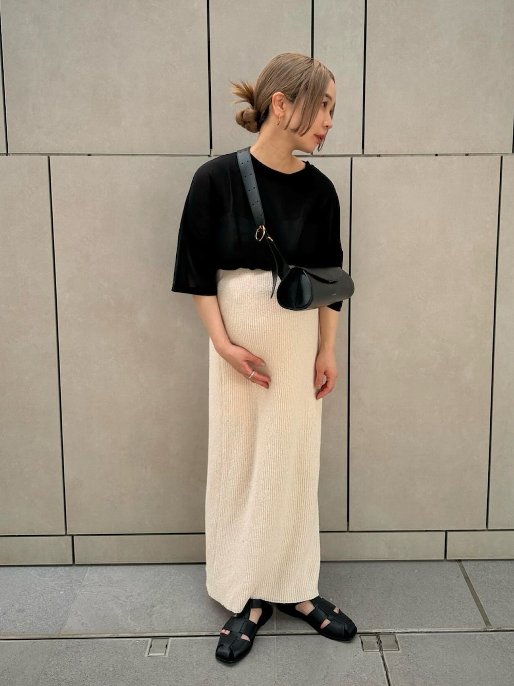 ブラック系のTシャツ/カットソー、ホワイト系のスカート、ブラック系のサンダルを着用したレディースの春コーディネートの3枚目の写真