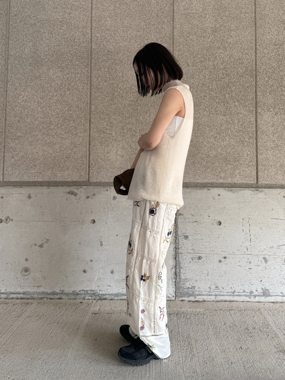 ホワイト系のニット/セーター、ホワイト系のその他パンツ、ブラウン系のハンドバッグを着用したレディースの春コーディネートの2枚目の写真