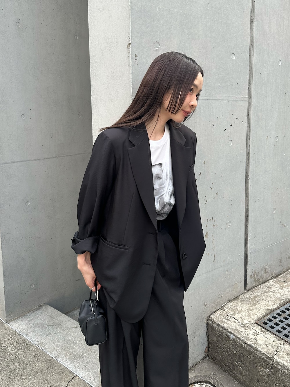 ブラック系のテーラードジャケット、ブラック系のスラックス、ホワイト系のTシャツ/カットソーを着用したレディースの春コーディネートの4枚目の写真