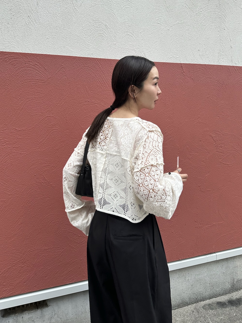 ホワイト系のカーディガン/ボレロ、ブラック系のスラックス、ブラック系のスニーカーを着用したレディースの春コーディネートの4枚目の写真