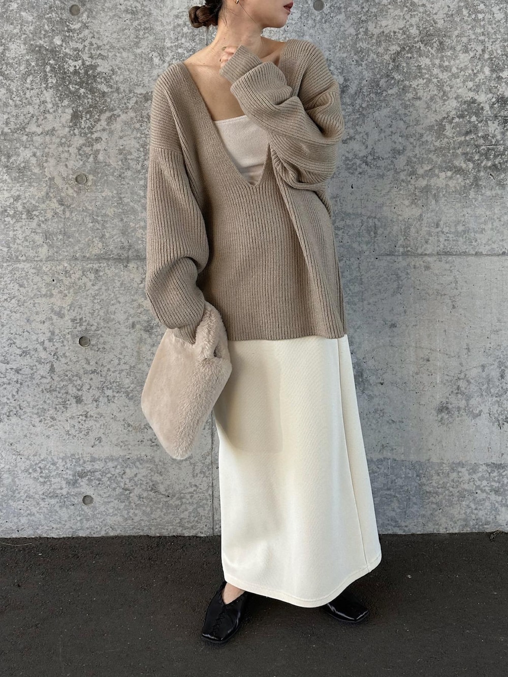 ベージュ系のニット/セーター、ホワイト系のスカート、ベージュ系のトートバッグを着用したレディースの秋コーディネートの5枚目の写真