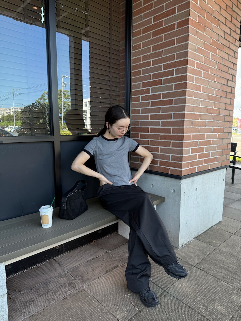 グレー系のTシャツ/カットソー、ブラック系のその他パンツ、ブラック系のハンドバッグを着用したレディースの秋コーディネートの2枚目の写真