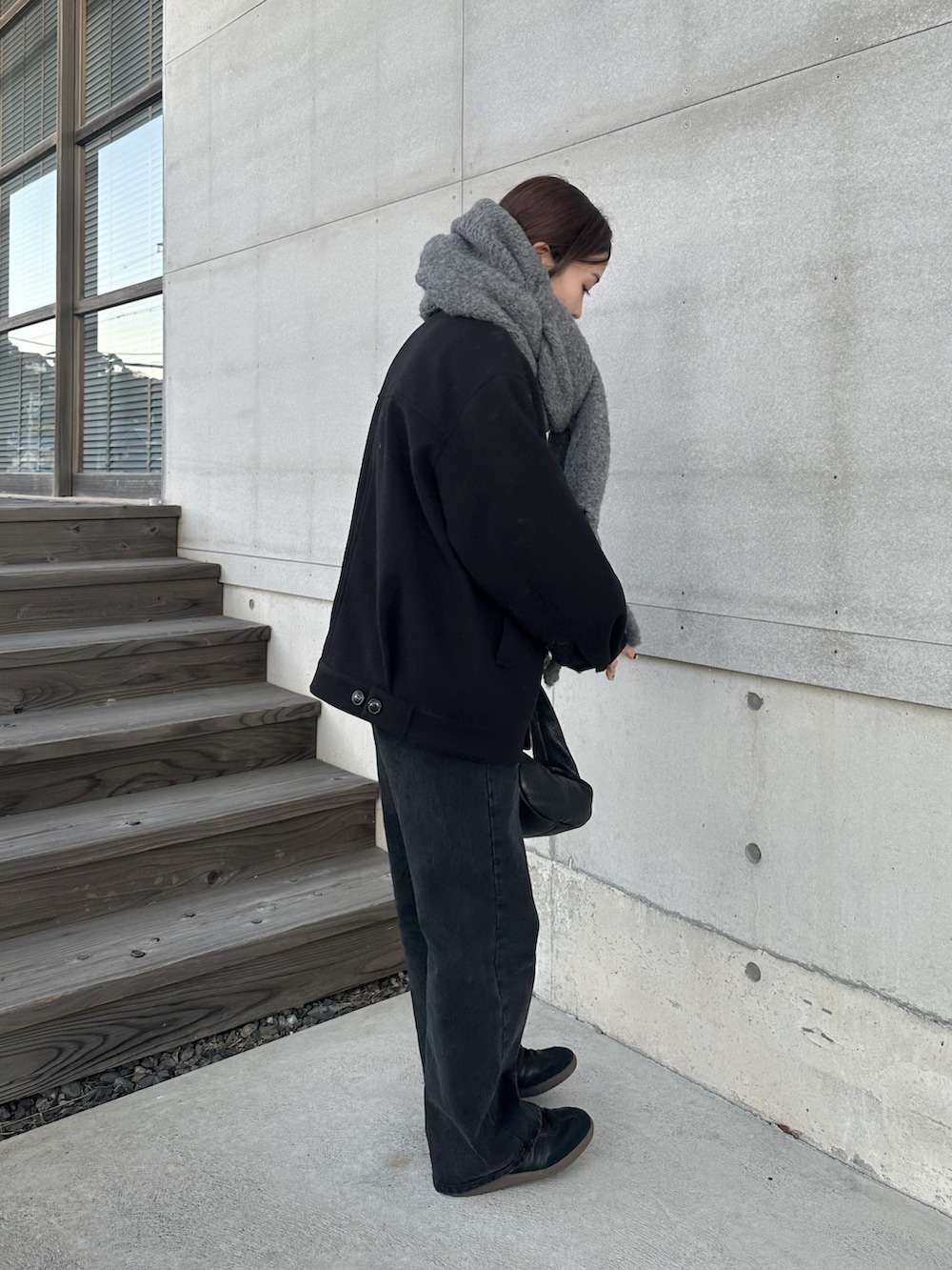 ブラック系のその他アウター、ブラック系のデニムパンツ、ブラック系のスニーカーを着用したレディースの冬コーディネートの5枚目の写真