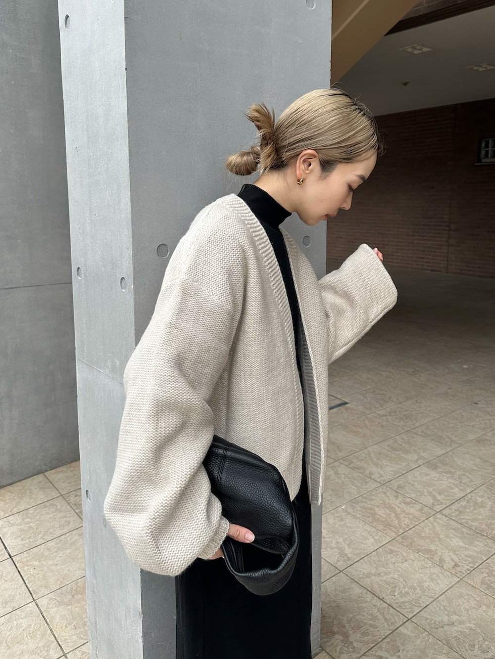 ホワイト系のカーディガン/ボレロ、ブラック系のワンピース、ブラック系のブーツを着用したレディースの秋コーディネートの4枚目の写真