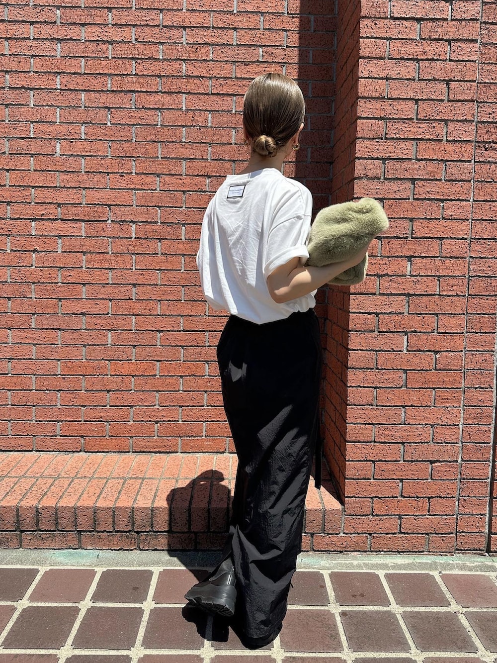 ホワイト系のTシャツ/カットソー、ブラック系のブーツ、グリーン系のハンドバッグを着用したレディースの夏コーディネートの2枚目の写真